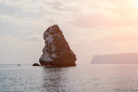 Close up shot of beautiful young caucasian woman with black hair and freckles looking at camera and smiling. Cute woman portrait in a pink bikini posing on a volcanic rock high above the sea