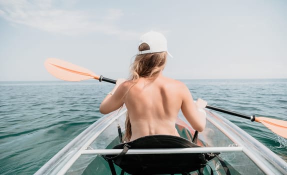 Woman in kayak back view. Happy young woman with long hair floating in transparent kayak on the crystal clear sea. Summer holiday vacation and cheerful female people having fun on the boat.