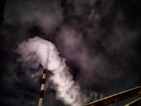 Winter night industrial landscape. Coal-fired power station with smoking chimneys against dramatic dark sky. Carbon dioxide CO2 emissions as primary driver of global climate change. Air pollution