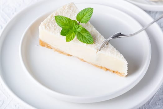 Slice of cheesecake with mint leaf. Copy space for text.