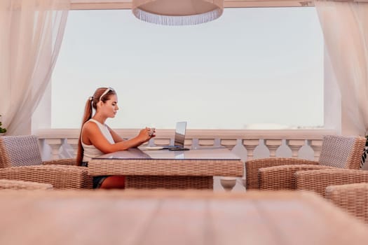 Woman coffee cafe laptop sea. Modern businessman in white uniform working on laptop in coffee shop. Woman sitting at a coffee shop with mobile phone drinking coffee