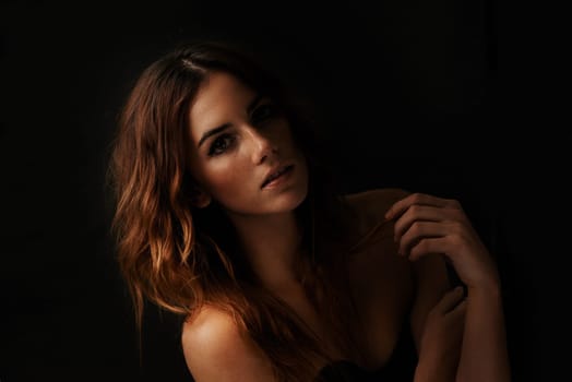 Woman, hair care and ginger with portrait, shadow and shampoo treatment in a studio. Relax, beauty and female person with wavy texture and fresh haircut with balayage coloring with black background.