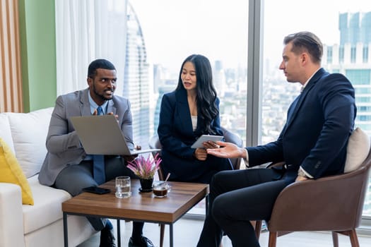 African businessman present start up project to expert investor. Group of multicultural business team solving problems, discussing business idea with skyscraper at modern business lounge. Ornamented