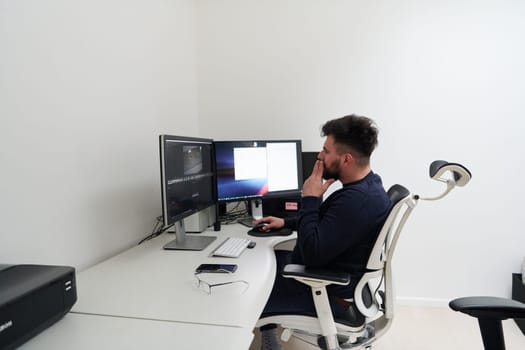 professional video editor enhancing digital footage using specialized software. Expert videographer in home office workspace editing on dual screen workstation computer desktop workplace