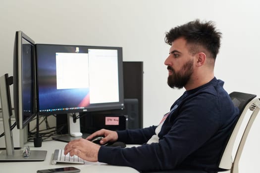 professional video editor enhancing digital footage using specialized software. Expert videographer in home office workspace editing on dual screen workstation computer desktop workplace