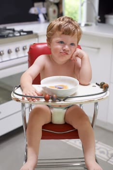 Eating, toddler and boy in chair for food, feeding or meal in house kitchen or home for breakfast. Hungry kid, baby thinking and healthy child with bowl for nutrition, natural diet or growth alone.