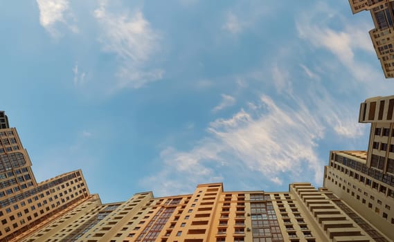 Roofs constructed high-rise apartments against sky. City panorama, construction site with cranes. Building house is frozen during quarantine. Losses from investments in building house