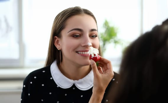 Girl stained her nose with cream from strawberries. Romantic dessert recipe. Girlfriends spend time together during quarantine. Tasty summer treat. Delicious healthy dessert for healthy diet