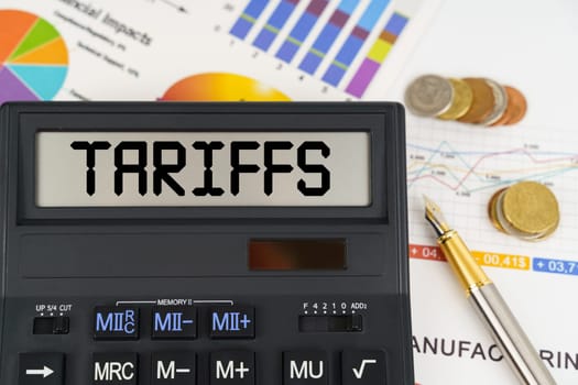 Business concept. On the table are financial reports, coins and a calculator with the inscription - Tariffs