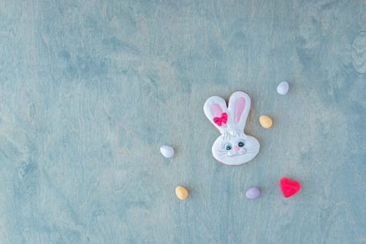 top view of Easter bunny with chocolate eggs and red heart on a wooden green background with space for text. copy space, flat lay, creative, Happy Easter,