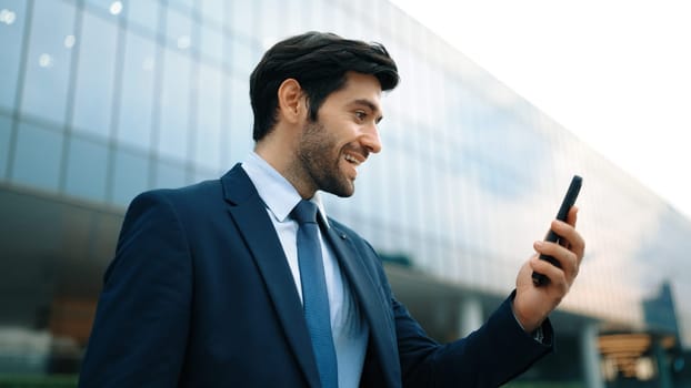 Successful business man celebrate increasing sales while standing. Happy project manager or leader proud with successful project, getting a promotion, getting a job while holding a phone. Exultant.