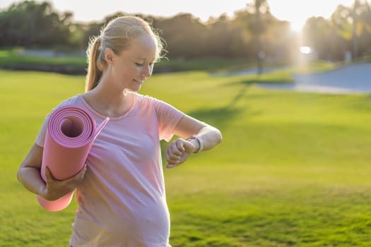 Energetic pregnant woman takes her workout outdoors, using an exercise mat for a refreshing and health-conscious outdoor exercise session.