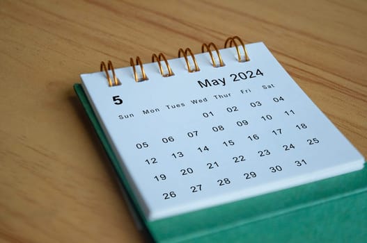 Close up side view of May 2024 calendar on wooden desk. Calendar concept.