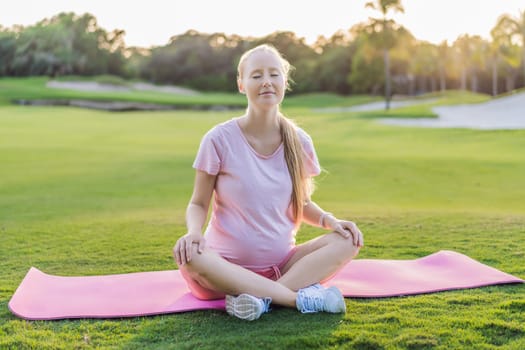 Energetic pregnant woman takes her workout outdoors, using an exercise mat for a refreshing and health-conscious outdoor exercise session.