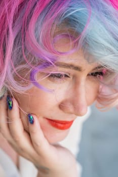 Close-up portrait of curly Caucasian woman with multi-colored hair. Model for hairstyles. Vertical photo