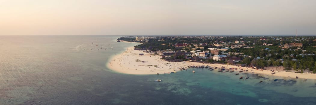 Panorama of the fishing boats on tropical sea coast with sandy beach.Summer travel in Zanzibar, Africa. Top view of boats and clear water.