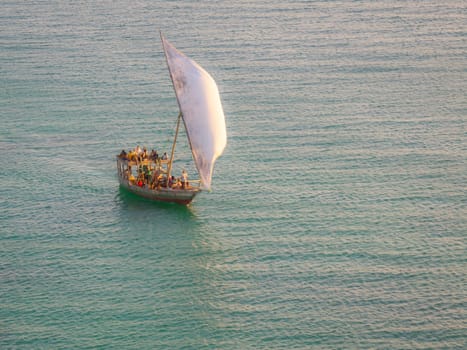 Dhow boat sails in the ocean at sunset, summer concept, copy-space, Zanzibar in Tanzania.
