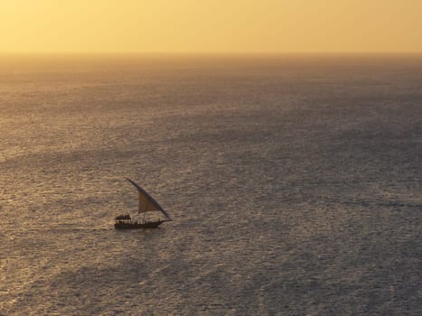 Summer concept, african boat sails in the ocean at sunset, Zanzibar, Tanzania.
