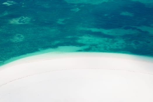 Drone view of white sandy beach in the green ocean, minimalist photo and copy space, summer concept, Zanzibar in Tanzania.