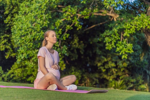 Energetic pregnant woman takes her workout outdoors, using an exercise mat for a refreshing and health-conscious outdoor exercise session.