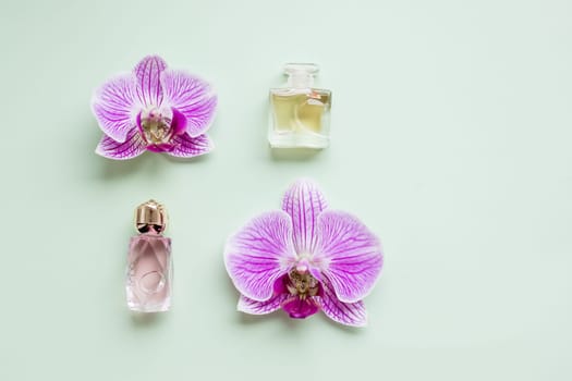 bottle of womens perfume and a delicate orchid flower