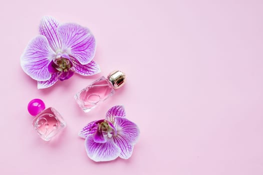 bottle of womens perfume and a delicate orchid flower