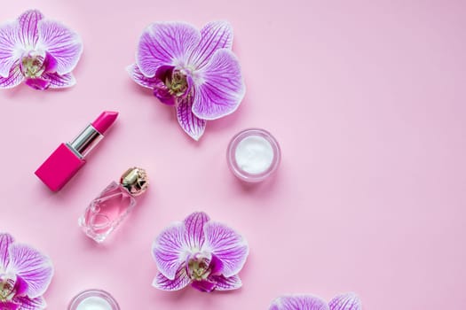 Beauty flat lay with cosmetic bottles and flowers. Top view.Copy space
