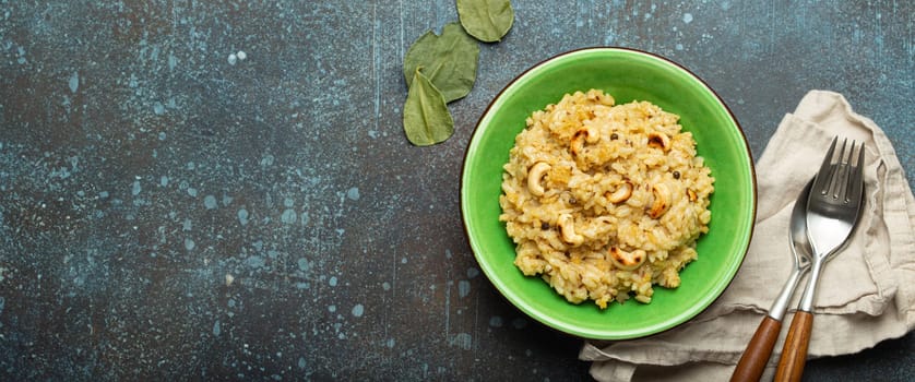 Ven Pongal (Khara Pongal), traditional Indian savoury rice dish made during celebrating Pongal festival, served in bowl top view on concrete rustic background, space for text.