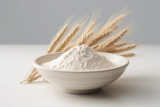 White flour in a bowl with wheat ears beside it