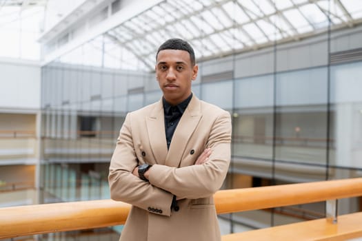 Businessman looking at the camera while standing alone in a modern workplace. High quality photo