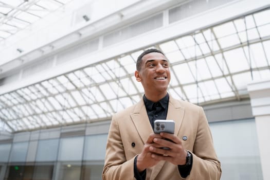 Businessman looking at the camera while standing alone in a modern workplace. High quality photo