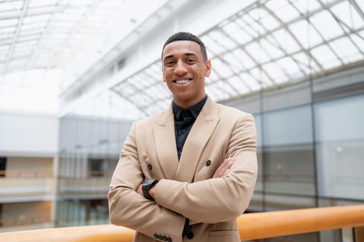 Businessman looking at the camera while standing alone in a modern workplace. High quality photo