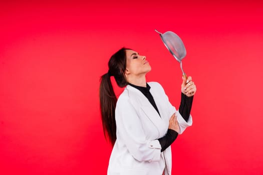 Female with metal sieve for sifting flour in a female hand on a red and white background.