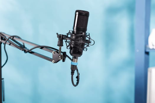Microphone for sound recording and audio podcast live streaming on radio close up. Professional black mic equipment for digital content creating in blogger modern empty studio
