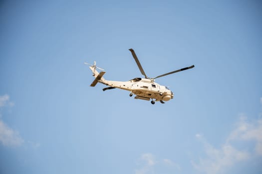 Helicopter in flight against blue sky showcasing modern rescue and transportation technology. New engine hovering capabilities. Pilot manages small aircraft's speed and angles.