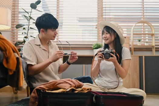 Lovely young couple preparing clothes, getting ready for honeymoon holiday trip.