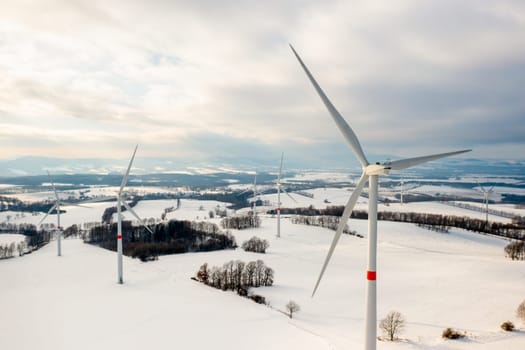 Panoramic view of wind turbines or windmills for production of a clean and renewable energy source in winter.