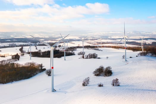 Panoramic view of a wind turbine park in the winter field as a hub of renewable energy production