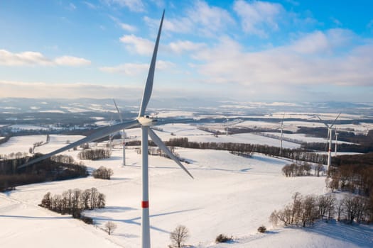 The wind turbines in a winter field at sunset.