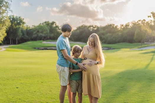 Joyful family time as a pregnant woman, her husband, and son share quality moments outdoors, embracing the beauty of nature and creating cherished memories together.