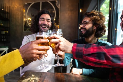 Happy male friends in a bar enjoying drinks together toasting with beer, having fun. Lifestyle concept.