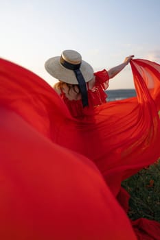 Woman poppy field red dress hat. Happy woman in a long red dress in a beautiful large poppy field. Blond stands with her back posing on a large field of red poppies