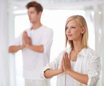 Meditation, prayer hands and people in a studio with peace, zen and mental health, wellness or balance. Mindfulness, relax and team with holistic, breathing or yoga exercise for spiritual awareness.
