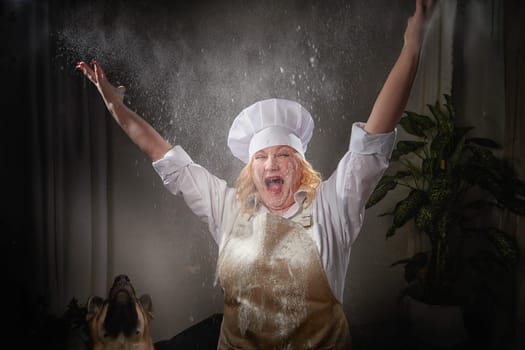 Fat funny female cook in a hat and apron posing and taking selfie in the kitchen with flour. Cooking, body positive, cloud, smoke, flour