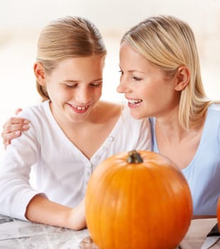 Happy, mother and child with pumpkin to celebrate halloween, party and fun together at home. Young girl, mom and family carving orange vegetable for holiday lantern, decoration or creativity of craft.