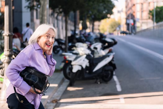 happy smiling senior woman looking before crossing a city street, concept of elderly people leisure and active lifestyle, copy space for text