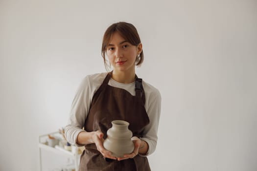 Confident entrepreneur crafts woman in pottery studio looking at camera