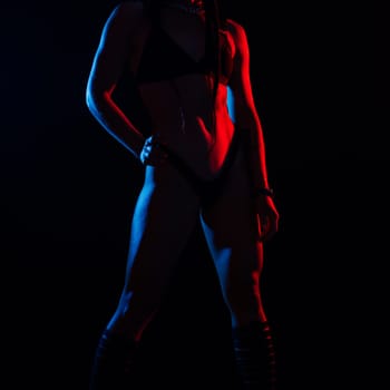 Young woman in underwear is in a studio with neon lights.