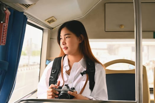 Attractive young woman traveling and looking through the bus window. Commuting and lifestyle concept.
