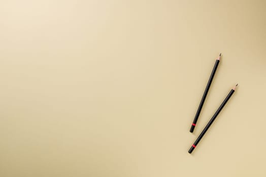 Pencil with black paint and a red stripe on a yellow background